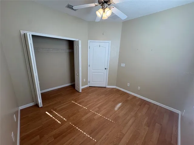 a view of an empty room with a chandelier fan