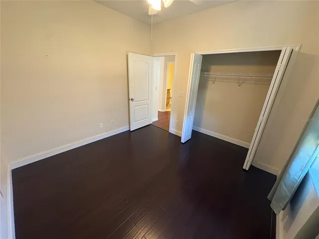 an empty room with wooden floor and closet