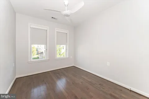 a kitchen with granite countertop a sink cabinets and wooden floor