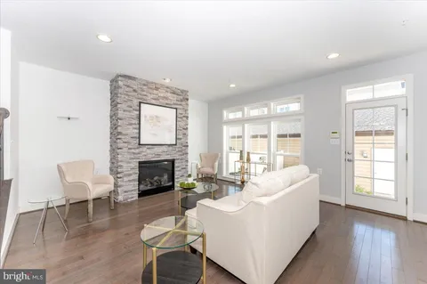 a living room with furniture a fireplace and a large window