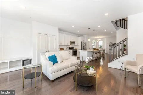 a dining room with wooden floor a chandelier a glass table and chairs