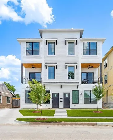a front view of a residential apartment building with a yard