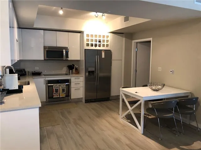 a kitchen with a table chairs refrigerator and a sink
