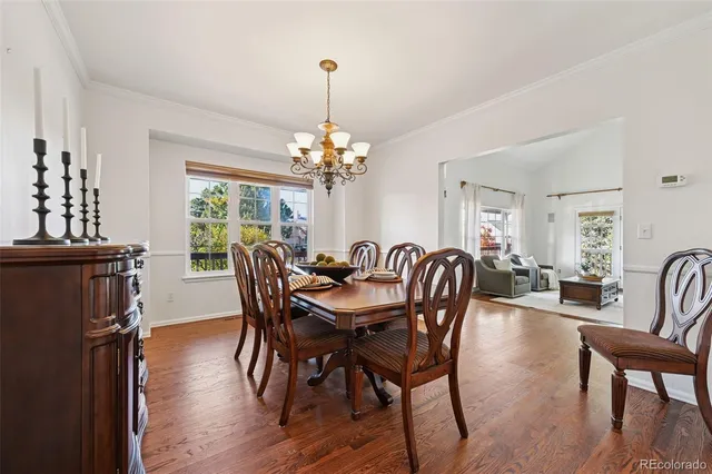 a dining room with furniture a chandelier and wooden floor