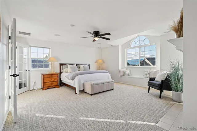 a bedroom with a bed a chandelier and a couch