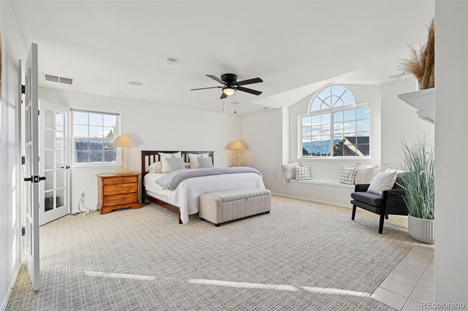 5575 Butler Court Colorado Springs, CO 80918 - Photo 19 of 47 a bedroom with a bed a chandelier and a couch