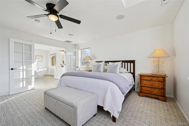 a spacious bedroom with a bed and ceiling fan