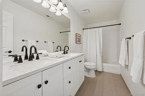 a bathroom with a double vanity sink mirror and toilet