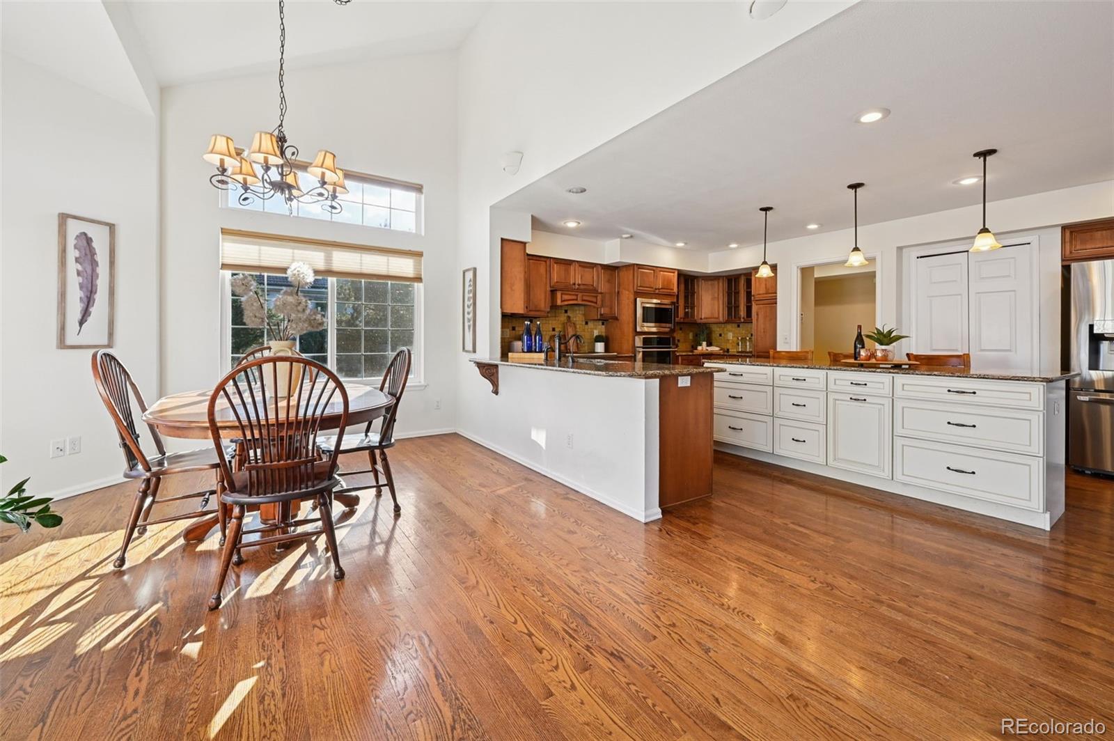 5575 Butler Court Colorado Springs, CO 80918 - Photo 9 of 47 a open kitchen with stainless steel appliances granite countertop a stove top oven a sink dishwasher and a dining table with wooden floor