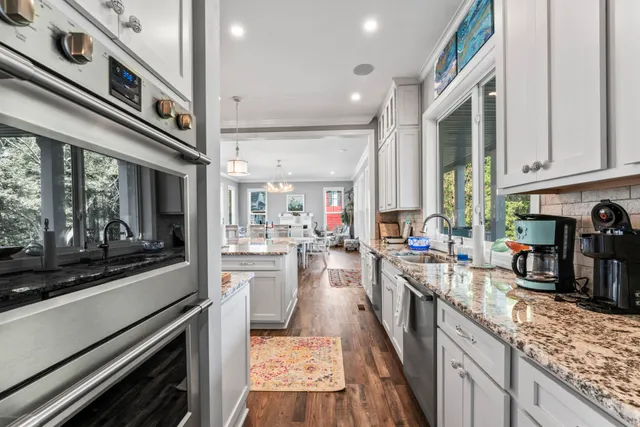 a spacious bedroom with a bed a dresser and a chandelier