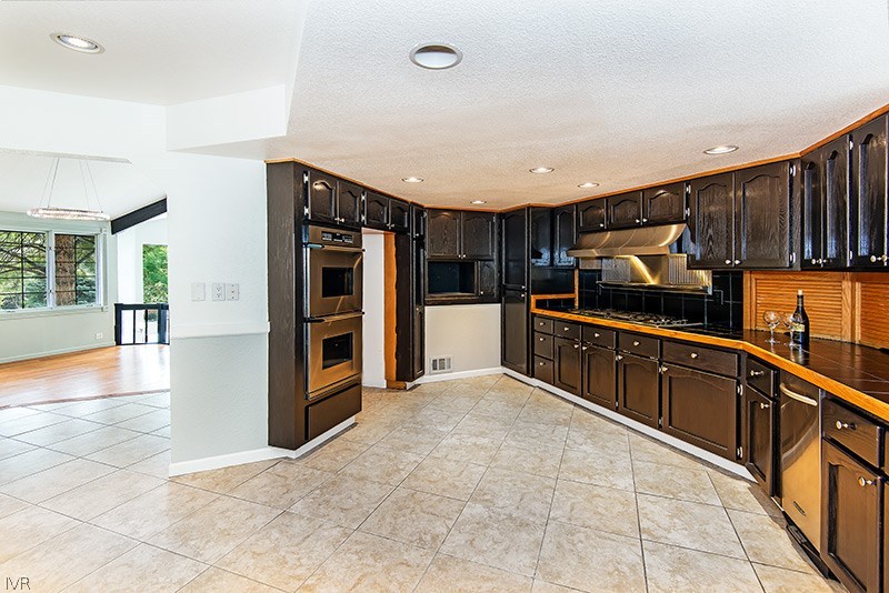 4125 Powderkeg Circle Reno, NV 89519 - Photo 2 of 11 a kitchen with granite countertop a refrigerator and a stove top oven