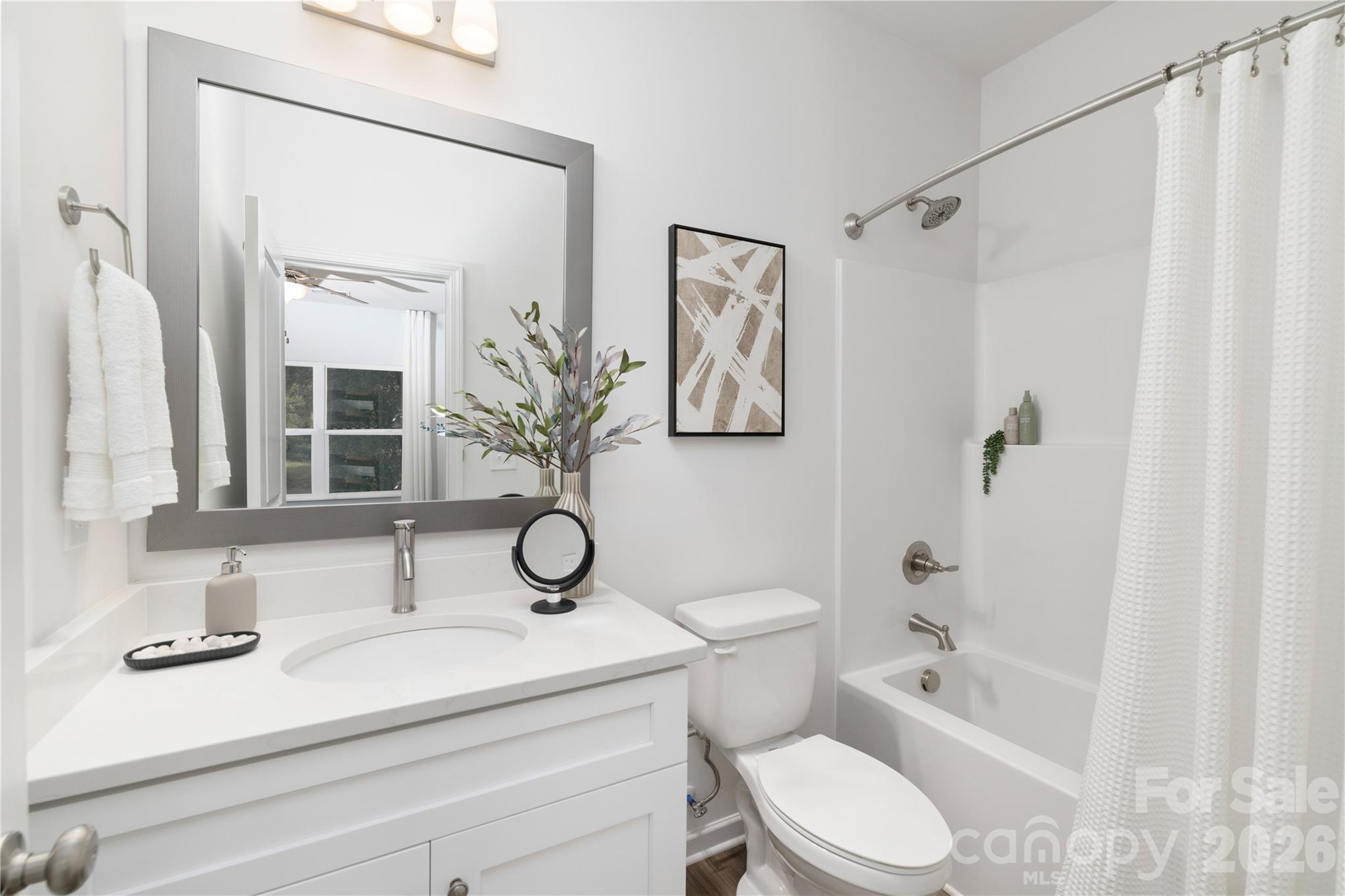 6924 Ridge Ln Road Charlotte, NC 28262 - Photo 18 of 24 a bathroom with a sink toilet a mirror a vanity and shower