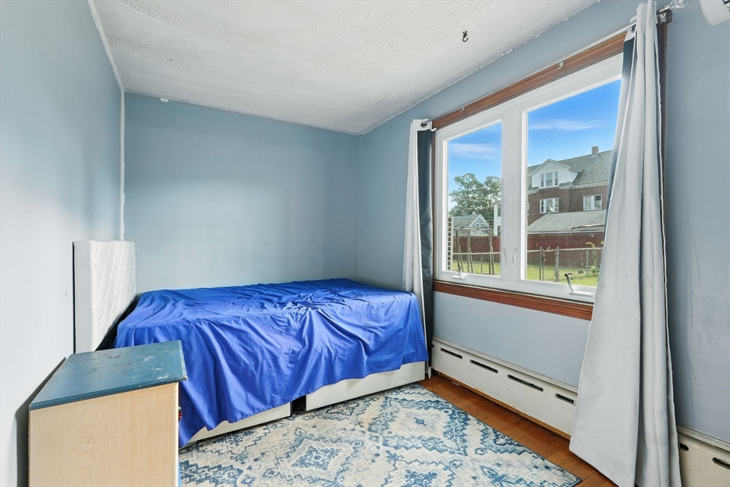 222-224 Main Street Springfield, MA 01151 - Photo 18 of 42 a bed sitting in a bedroom next to a window