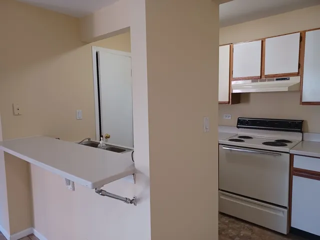 a living room with stainless steel appliances white cabinets and a window