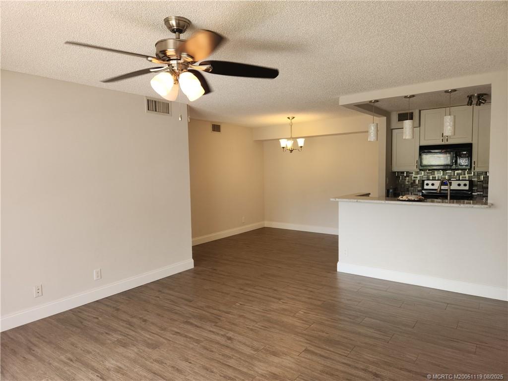 2502 Southeast Anchorage Cove, Unit H2 Port St. Lucie, FL 34952 - Photo 11 of 37 a view of a room with wooden floor and a ceiling fan