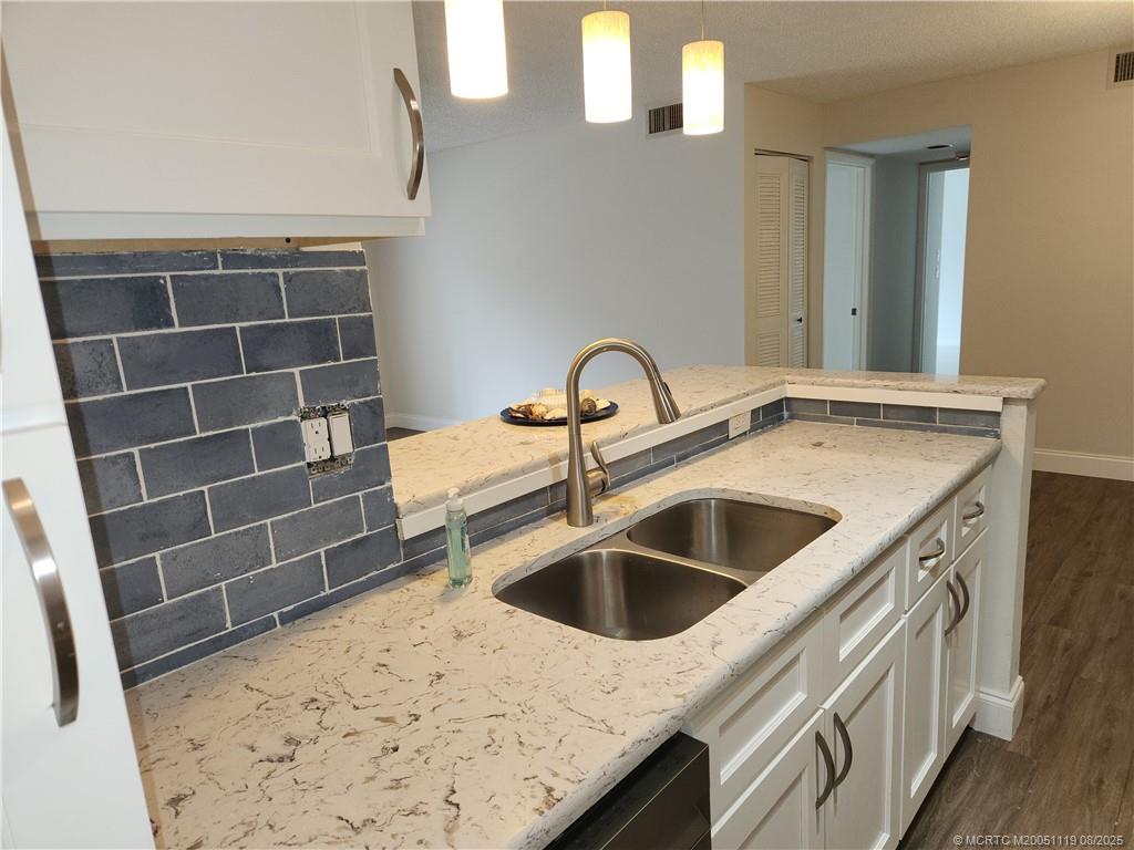 2502 Southeast Anchorage Cove, Unit H2 Port St. Lucie, FL 34952 - Photo 15 of 37 a kitchen with a sink and a stove with wooden floor