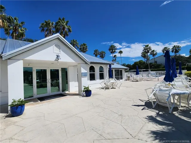 a view of a house with a swimming pool and a porch with furniture