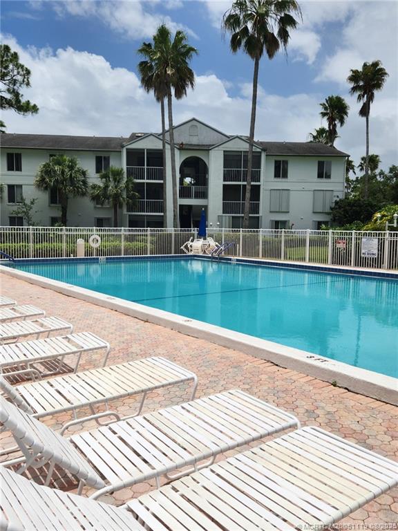 2502 Southeast Anchorage Cove, Unit H2 Port St. Lucie, FL 34952 - Photo 28 of 37 a view of a house with a swimming pool and a porch with furniture