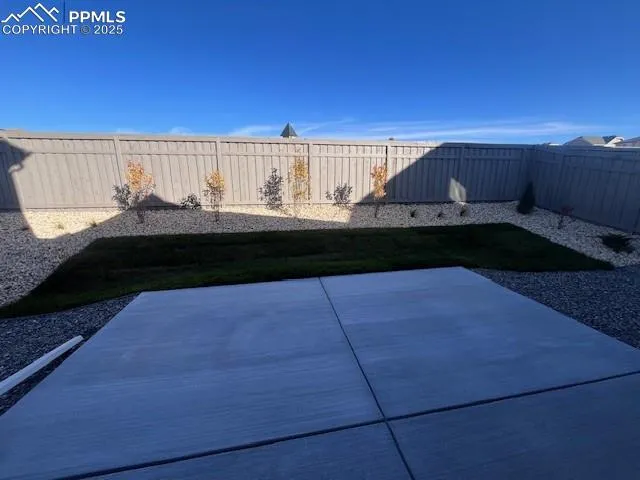 a view of a backyard with wooden fence