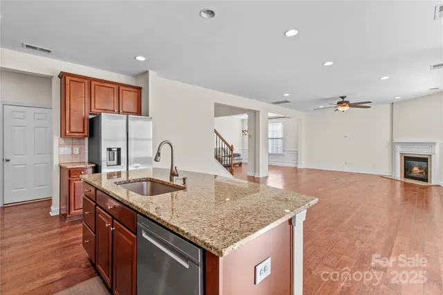 a kitchen with stainless steel appliances granite countertop a sink a stove and a refrigerator