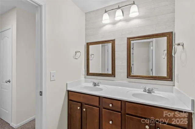 a bathroom with double sink and a mirror