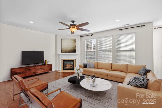 a living room with furniture a fireplace and a flat screen tv
