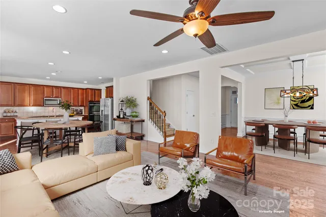 a living room with furniture kitchen view and a chandelier