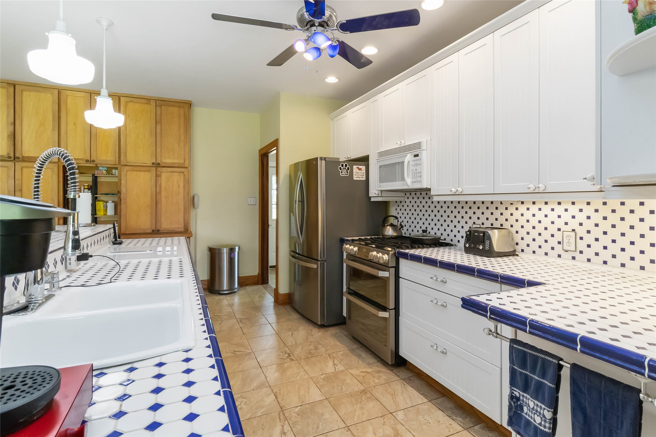 1208 Jeddo Road Rosanky, TX 78953 - Photo 9 of 40 A vibrant kitchen features a bold blue and white tiled countertop and backsplash, perfectly complemented by a stainless steel range.