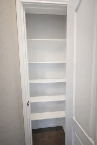 a view of walk in closet with empty racks