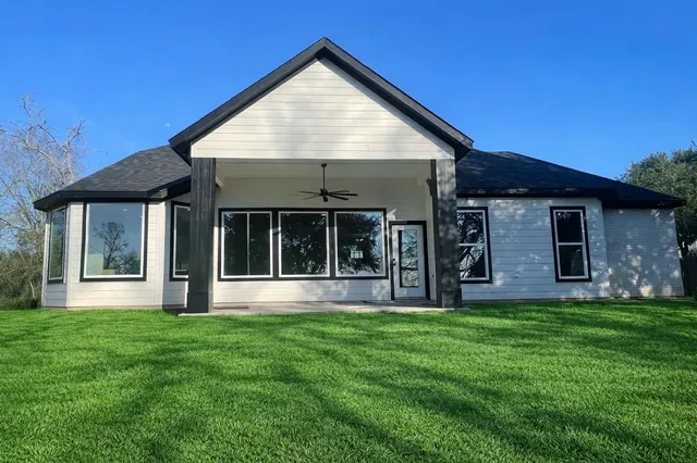 a view of a brick house with a large window and a yard