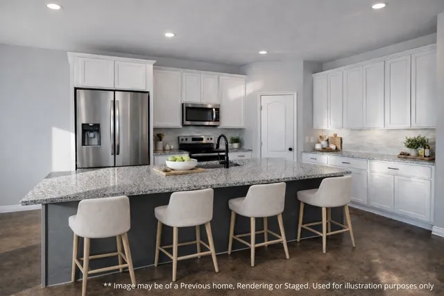 a kitchen with granite countertop a table chairs stove and refrigerator