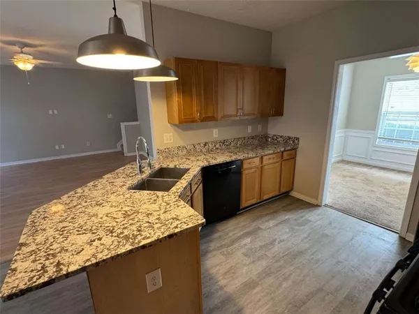 a kitchen with kitchen island granite countertop wooden cabinets and a stove