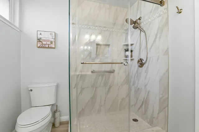 a bathroom with a granite countertop sink mirror and toilet