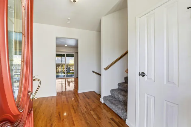 a view of a hallway with wooden floor and entryway