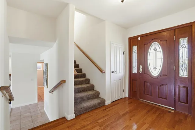 a view of a hallway with wooden floor and entryway