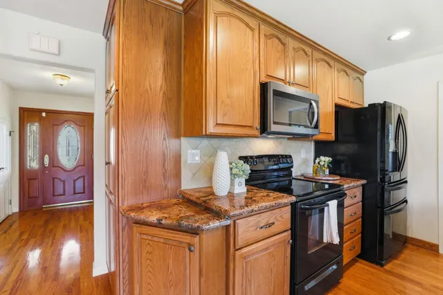 a kitchen with stainless steel appliances granite countertop a stove a refrigerator and a microwave