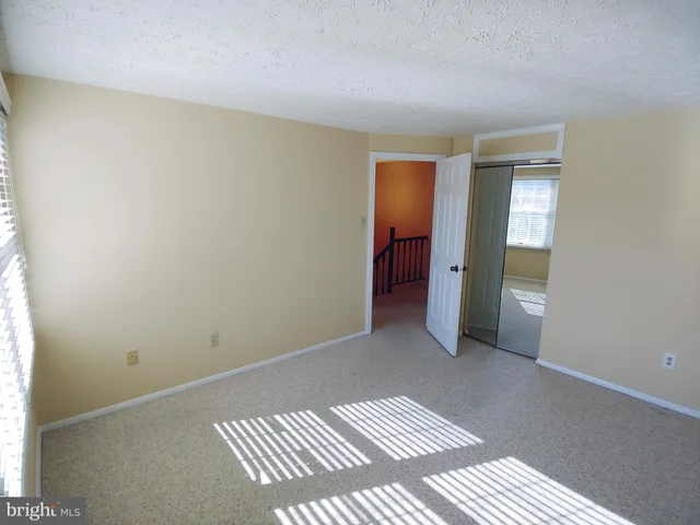 a view of a room with a hallway and wooden floor