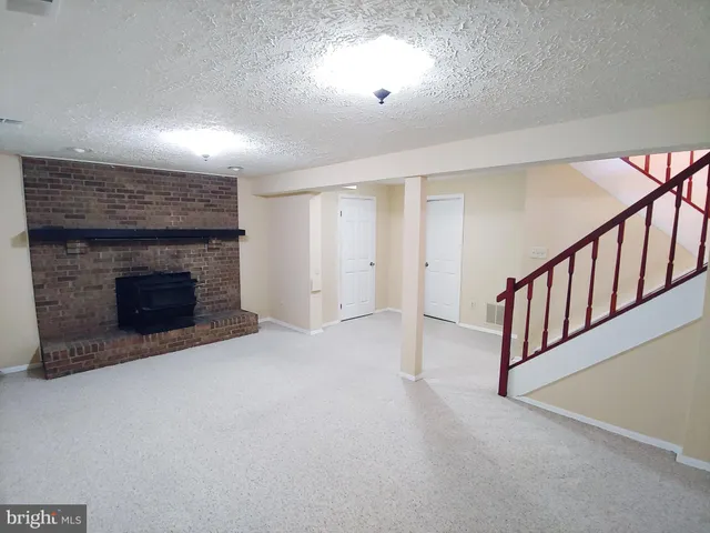 an empty room with fireplace and a window