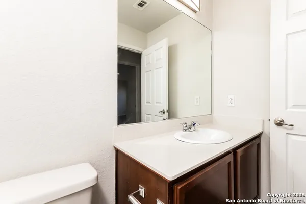 a bathroom with a sink a toilet and a mirror