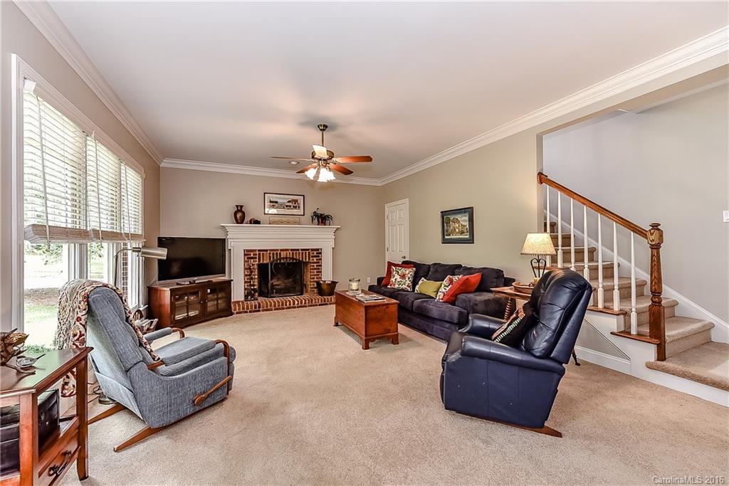 325 Kimberly Road Davidson, NC 28036 - Photo 11 of 22 a living room with furniture a fireplace and a flat screen tv