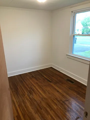 a view of a room with wooden floor and window