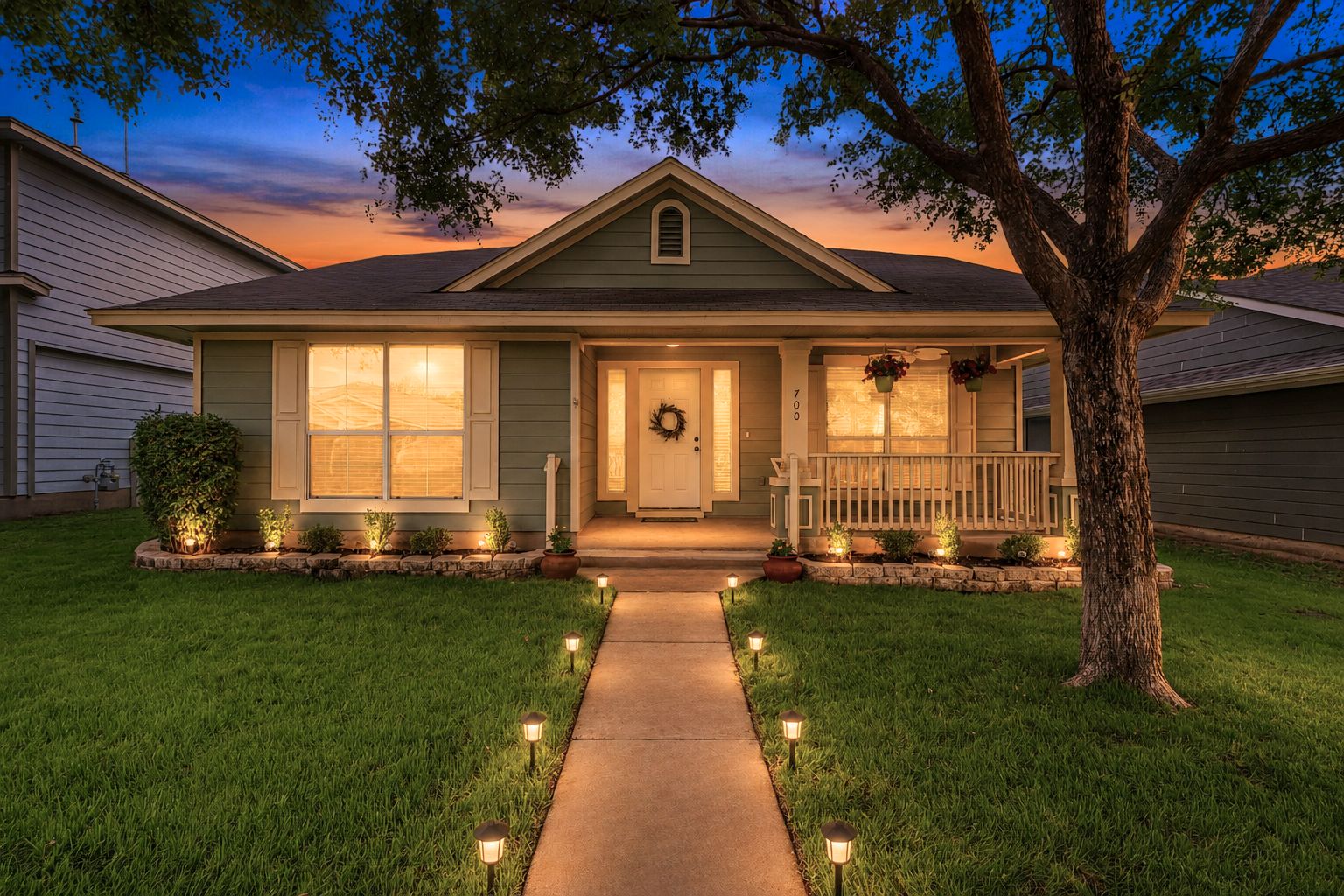 700 Scheel Road Kyle, TX 78640 - Photo 1 of 39 Single-story home featuring a covered front porch with white railing, a concrete walkway, and a landscaped front yard with path lighting