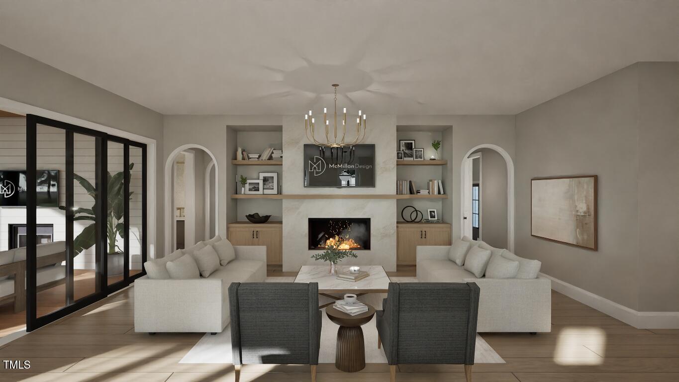 913 Tyrrell Road Raleigh, NC 27609 - Photo 8 of 42 a living room with furniture a fireplace and a chandelier