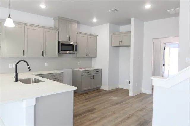 a room with kitchen island a sink and a refrigerator