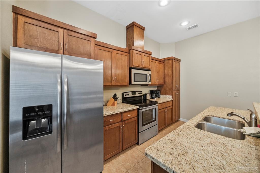 2715 Mimosa Street, Unit 9 Mission, TX 78574 - Photo 8 of 21 a kitchen with stainless steel appliances granite countertop a refrigerator a stove and a sink