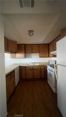 a view of a kitchen with a sink refrigerator and cabinets