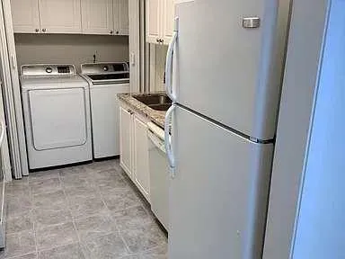 a kitchen with white cabinets and white appliances