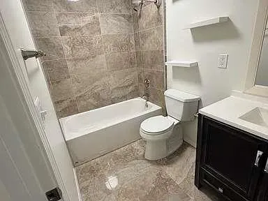 a white toilet sitting next to a bath tub