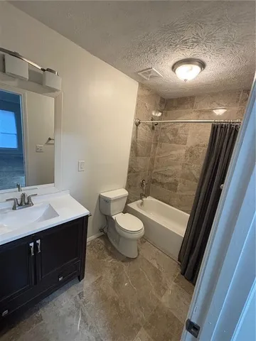 a bathroom with a sink a toilet a mirror and shower