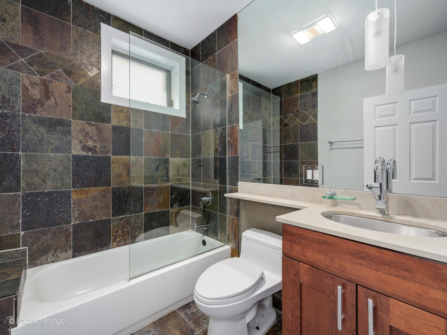 1834 West Rice Street, Unit A Chicago, IL 60622 - Photo 21 of 23 a bathroom with a sink a toilet a mirror a bathtub and shower